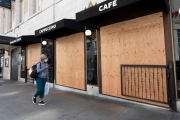 An pedestrian walks by a Starbucks Coffee  that is covered with plywood  to discourage looting in San Francisco on March 31, 2020 .
Millions of San Francisco Bay Area  residents were ordered to stay home for the third week to slow the spread of the coronavirus as part of a lockdown effort.