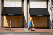 An pedestrian walks by the Saks Fifth Avenue luxury store that is covered with plywood  to discourage looting in San Francisco on March 31, 2020 .
Millions of San Francisco Bay Area  residents were ordered to stay home for the third week to slow the spread of the coronavirus as part of a lockdown effort.