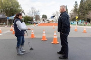 Local KCBS radio reporter Holly Quan uses a long plastic  tube to hold her microphone so she can keep a safe distance from  Hayward Fire Captain Don Nicholson during an interview at the COVID-19 testing center in Hayward, CA, on March 23, 2020.  
The free test facility opened to  to the public this morning regardless of where the patients live or their immigration status. 
The entire state of California is on a shelter-in-place status ordered by the governor to slow the spread of the COVID-19 disease.