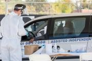 A health care worker tests a man for COVID-19 at a testing drive-through center in Hayward, CA, on April 15, 2020.  Hayward firefighters with cooperation with Hayward Police and paramedics set up the center to take pressure off hospital emergency rooms. It is free and available to anyone who show symptoms such as fever.