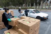 Members of the Hope Ministries Church load a box of food in a car at a drive-through food distribution in South San Francisco, CA, on April 8, 2020.  The food drive was organized to help families in need during the COVID-19 pandemic.