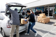 Members of the Hope Ministries Church load a box of food in a car at a drive-through food distribution in South San Francisco, CA, on April 8, 2020.  The food drive was organized to help families in need during the COVID-19 pandemic.