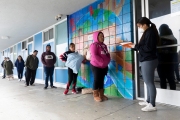 A member of the Hope Ministries Church check-in residents who line up tp pick up food in South San Francisco, CA, on April 8, 2020.  The food drive was organized to help families in need during the COVID-19 pandemic.