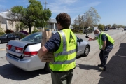 A volunteer gets ready to load  bags of food into the trunk of car  at the Alameda Food Bank distribution center in Alameda, CA, on April 15, 2019. The food was distributed through a drive-through to people in need following the loss of their jobs due to the “shelter-in-place” order to limit the spread of the coronavirus SARS-CoV-2.