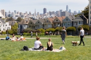 People enjoy a sunny and warm day at the Alamo Square Park in san Francisco, CA, on April 25, 2020, despite a current shelter-at-home order due to COVID-19 .  On the right are the famous houses bettie known as the Painted Ladies.