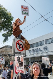 Demonstrators gather outside the Tesla dealership in San Francisco, CA, on March 29, 2025, as part of the global "Tesla Takedown" protests. These protests, spanning over 200 locations worldwide, were organized to oppose Elon Musk's involvement with the U.S. federal government and the associated budget cuts and layoffs. The protesters held signs and chanted slogans to express their discontent with Musk's actions. The movement encourages individuals to boycott Tesla products and divest from Tesla stock, aiming to impact the company's financial standing as a form of protest.