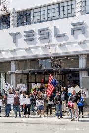 Demonstrators gather outside the Tesla dealership in San Francisco, CA, on March 29, 2025, as part of the global "Tesla Takedown" protests. These protests, spanning over 200 locations worldwide, were organized to oppose Elon Musk's involvement with the U.S. federal government and the associated budget cuts and layoffs. The protesters held signs and chanted slogans to express their discontent with Musk's actions. The movement encourages individuals to boycott Tesla products and divest from Tesla stock, aiming to impact the company's financial standing as a form of protest.