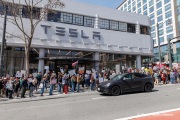 Demonstrators gather outside the Tesla dealership in San Francisco, CA, on March 29, 2025, as part of the global "Tesla Takedown" protests. These protests, spanning over 200 locations worldwide, were organized to oppose Elon Musk's involvement with the U.S. federal government and the associated budget cuts and layoffs. The protesters held signs and chanted slogans to express their discontent with Musk's actions. The movement encourages individuals to boycott Tesla products and divest from Tesla stock, aiming to impact the company's financial standing as a form of protest.