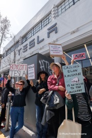 Demonstrators gather outside the Tesla dealership in San Francisco, CA, on March 29, 2025, as part of the global "Tesla Takedown" protests. These protests, spanning over 200 locations worldwide, were organized to oppose Elon Musk's involvement with the U.S. federal government and the associated budget cuts and layoffs. The protesters held signs and chanted slogans to express their discontent with Musk's actions. The movement encourages individuals to boycott Tesla products and divest from Tesla stock, aiming to impact the company's financial standing as a form of protest.