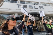 Demonstrators gather outside the Tesla dealership in San Francisco, CA, on March 29, 2025, as part of the global "Tesla Takedown" protests. These protests, spanning over 200 locations worldwide, were organized to oppose Elon Musk's involvement with the U.S. federal government and the associated budget cuts and layoffs. The protesters held signs and chanted slogans to express their discontent with Musk's actions. The movement encourages individuals to boycott Tesla products and divest from Tesla stock, aiming to impact the company's financial standing as a form of protest.