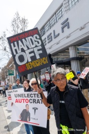 Demonstrators gather outside the Tesla dealership in San Francisco, CA, on March 29, 2025, as part of the global "Tesla Takedown" protests. These protests, spanning over 200 locations worldwide, were organized to oppose Elon Musk's involvement with the U.S. federal government and the associated budget cuts and layoffs. The protesters held signs and chanted slogans to express their discontent with Musk's actions. The movement encourages individuals to boycott Tesla products and divest from Tesla stock, aiming to impact the company's financial standing as a form of protest.