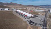 The Switch data center campus at the Tahoe Reno Industrial Center (TRIC), east of Sparks, NV, is one of the largest data center developments in the world and a defining symbol of the hyperscale infrastructure transforming northern Nevada into a major technology hub. Known for its massive, highly secure facilities, Switch built the campus to support cloud computing, enterprise data storage, and artificial intelligence workloads for large corporate clients. The company was drawn to TRIC by Nevada’s favorable tax structure, available land, access to renewable energy, and fast fiber connections to the Bay Area. The campus also uses an advanced cooling system designed for the desert climate, relying heavily on outside air and evaporative cooling technologies to reduce energy consumption while maintaining stable temperatures for thousands of servers operating around the clock. Surrounded by desert landscapes and heavy industrial development, the sprawling campus reflects the enormous physical footprint and energy demands of the digital economy powering modern internet and AI services.