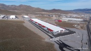 The Switch data center campus at the Tahoe Reno Industrial Center (TRIC), east of Sparks, NV, is one of the largest data center developments in the world and a defining symbol of the hyperscale infrastructure transforming northern Nevada into a major technology hub. Known for its massive, highly secure facilities, Switch built the campus to support cloud computing, enterprise data storage, and artificial intelligence workloads for large corporate clients. The company was drawn to TRIC by Nevada’s favorable tax structure, available land, access to renewable energy, and fast fiber connections to the Bay Area. The campus also uses an advanced cooling system designed for the desert climate, relying heavily on outside air and evaporative cooling technologies to reduce energy consumption while maintaining stable temperatures for thousands of servers operating around the clock. Surrounded by desert landscapes and heavy industrial development, the sprawling campus reflects the enormous physical footprint and energy demands of the digital economy powering modern internet and AI services.