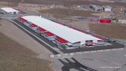 The Switch data center campus at the Tahoe Reno Industrial Center (TRIC), east of Sparks, NV, is one of the largest data center developments in the world and a defining symbol of the hyperscale infrastructure transforming northern Nevada into a major technology hub. Known for its massive, highly secure facilities, Switch built the campus to support cloud computing, enterprise data storage, and artificial intelligence workloads for large corporate clients. The company was drawn to TRIC by Nevada’s favorable tax structure, available land, access to renewable energy, and fast fiber connections to the Bay Area. The campus also uses an advanced cooling system designed for the desert climate, relying heavily on outside air and evaporative cooling technologies to reduce energy consumption while maintaining stable temperatures for thousands of servers operating around the clock. Surrounded by desert landscapes and heavy industrial development, the sprawling campus reflects the enormous physical footprint and energy demands of the digital economy powering modern internet and AI services.