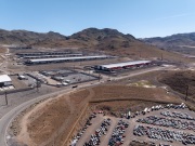 The Switch data center campus at the Tahoe Reno Industrial Center (TRIC), east of Sparks, NV, is one of the largest data center developments in the world and a defining symbol of the hyperscale infrastructure transforming northern Nevada into a major technology hub. Known for its massive, highly secure facilities, Switch built the campus to support cloud computing, enterprise data storage, and artificial intelligence workloads for large corporate clients. The company was drawn to TRIC by Nevada’s favorable tax structure, available land, access to renewable energy, and fast fiber connections to the Bay Area. The campus also uses an advanced cooling system designed for the desert climate, relying heavily on outside air and evaporative cooling technologies to reduce energy consumption while maintaining stable temperatures for thousands of servers operating around the clock. Surrounded by desert landscapes and heavy industrial development, the sprawling campus reflects the enormous physical footprint and energy demands of the digital economy powering modern internet and AI services.