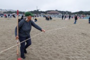 Volunteers work to lay out the design of a human banner on a beach in San Francisco on March 27, 2026. The “No Kings” protests drew thousands of people across the city as part of a nationwide day of action opposing President Donald Trump’s administration. The rallies were among thousands held across the United States, with demonstrators raising concerns about what they describe as threats to free speech, voting rights, and the war in Iran.