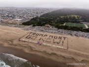 Volunteers form a human banner on a beach in San Francisco on March 27, 2026. The “No Kings” protests drew thousands of people across the city as part of a nationwide day of action opposing President Donald Trump’s administration. The rallies were among thousands held across the United States, with demonstrators raising concerns about what they describe as threats to free speech, voting rights, and the war in Iran.