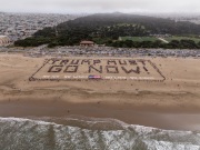 Volunteers form a human banner on a beach in San Francisco on March 27, 2026. The “No Kings” protests drew thousands of people across the city as part of a nationwide day of action opposing President Donald Trump’s administration. The rallies were among thousands held across the United States, with demonstrators raising concerns about what they describe as threats to free speech, voting rights, and the war in Iran.