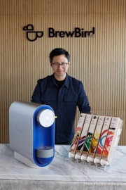 Mickey Du, founder and CEO of BrewBird, poses with his coffee brewer at the company‚Äôs headquarters in San Carlos, CA, on April 3, 2026.BrewBird is rethinking office coffee by combining whole beans in compostable pods with smart brewing technology to deliver a fresh, barista-quality cup in about a minute.