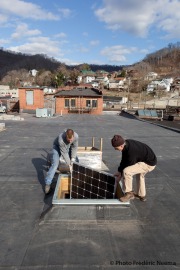 Installation of PV panels by Mountain View Solar and Wind Co. on the rooftop of a building in downtown Williamson.