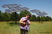 Fran Upp with Violet the chicken under the solar panels on her property in Princeton, Nebraska