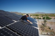 Tom Gendill cleaning the solar panels installed to cover a patio in his house in Mesa, AZ, on May 22, 2010.